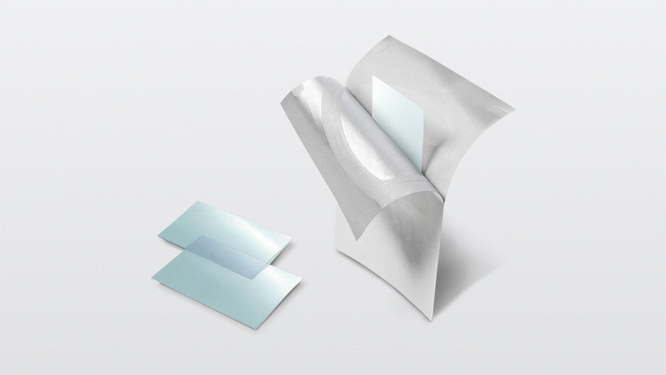 Three translucent light blue rectangular sheets or cards arranged on a clean white studio background, with one standing upright and two lying flat.