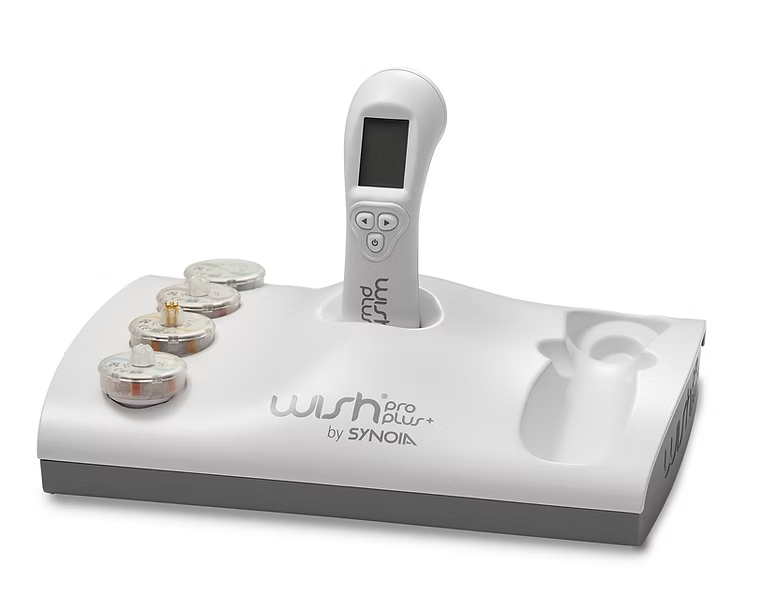 WISHpro plus - product image shows an off-white base with WishPro Plus+ by Synoia written on it, handpiece with user buttons, and three product capsules. Image is set on a white background. This product is great for heath and beauty, primarily designed for skin care.